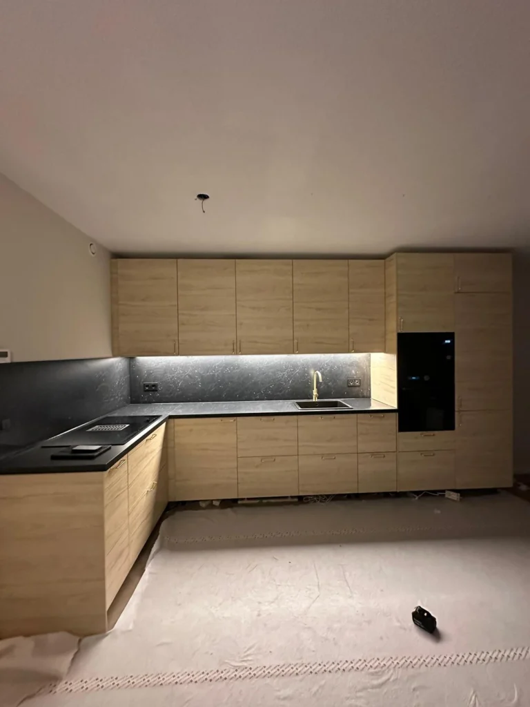 Gemonteerde IKEA METOD hoekkeuken met houtlook fronten, zwart werkblad en ingebouwde oven. Metod keukenmontage in Utrecht